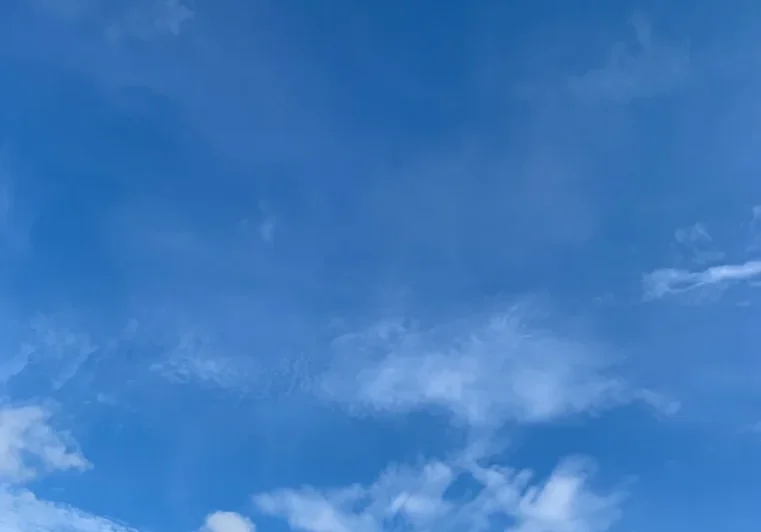 A blue sky with some clouds in the background